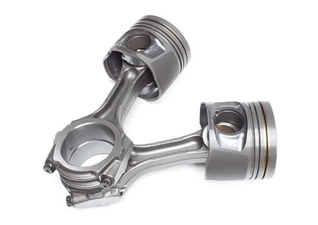 Two metallic pistons with attached connecting rods, ready for installation into an engine block.