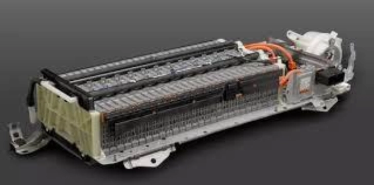 A high-voltage battery pack used in hybrid vehicles, with visible cells and orange wiring.