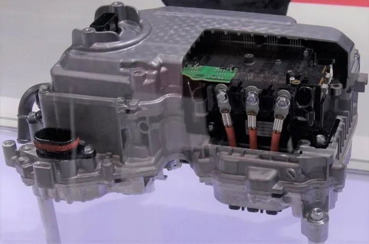 A power control unit (PCU) for a hybrid vehicle, with a portion of the casing removed to show internal electronic components and wiring.